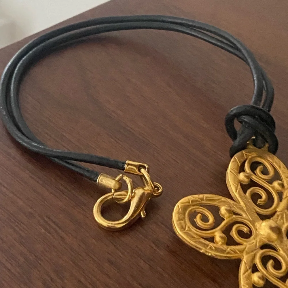 𝅺gold tone choker style necklace on leather cord